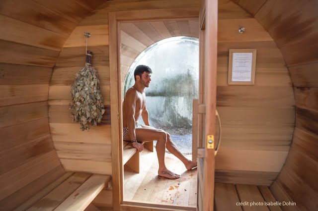 Un sauna en bois à L'Alpage Un homme est assis dans un sauna en bois à L'Alpage.