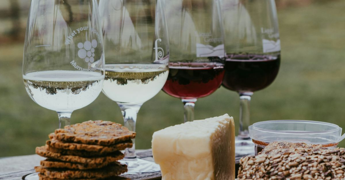 Quatre verres de vin et un assortiment de fromages