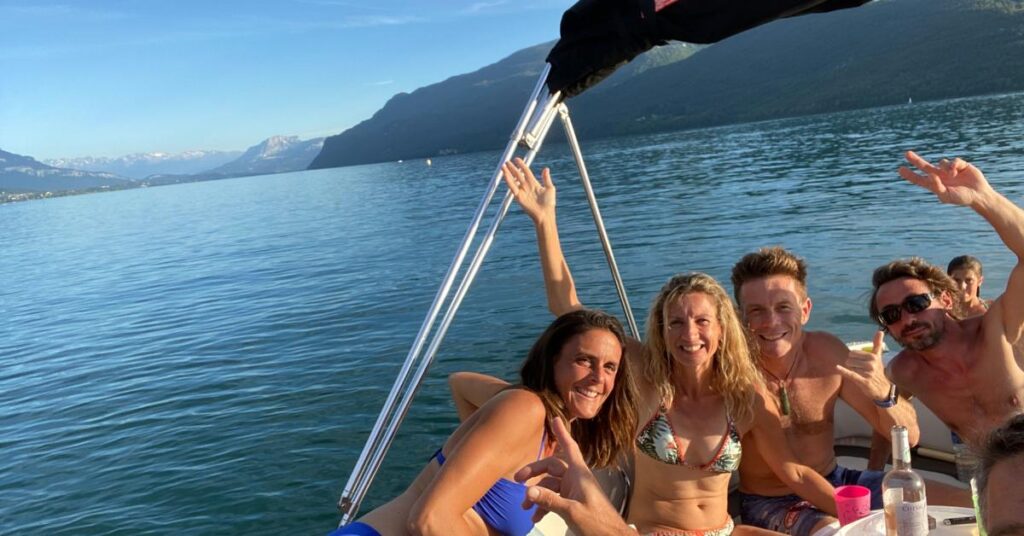 Groupe d'amis faisant du bateau à moteur sur le lac du Bourget 4 amis et un enfant sont sur un bateau à moteur et naviguent sur le lac du Bourget