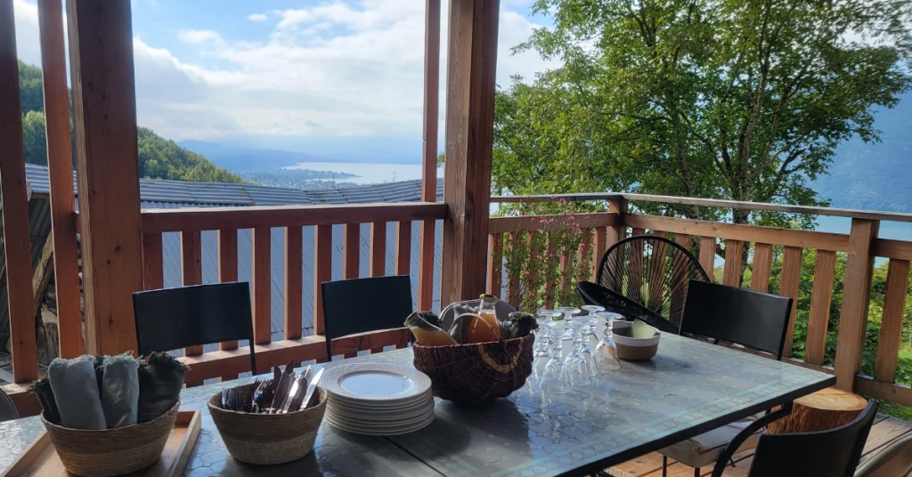 Une table est dressée pour accueillir un bubbet petit déjeuner dans le cadre d'un séminaire au vert à L'Alpage, avec sur sur le lac du Bourget.