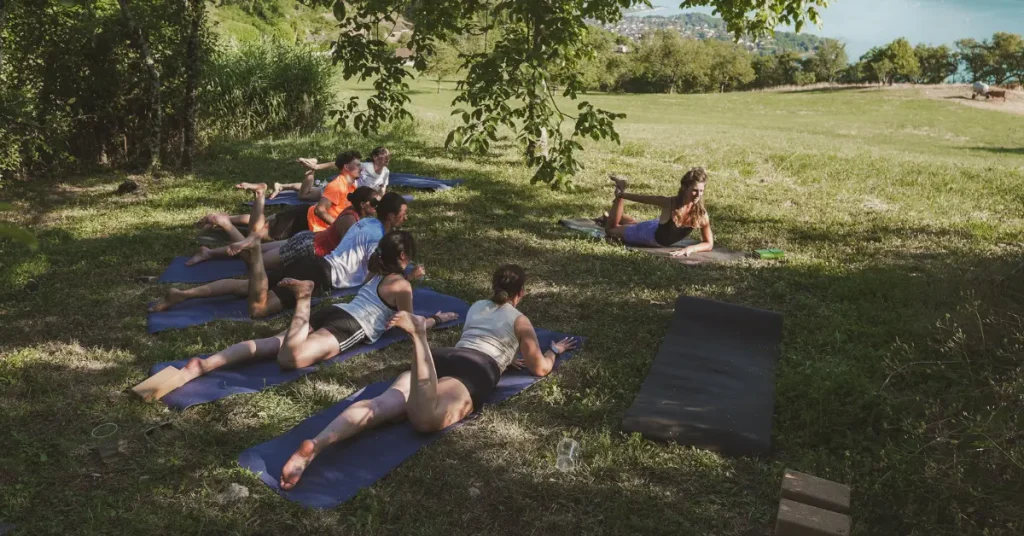 Un groupe participe à un cours de yoga face au lac du Bourget, à L'Alpage, pendant un stage bien-être.